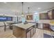 Kitchen with dark wood cabinets, a center island with seating, laminate wood floors and view to Living Room at 134 Comiskey Park Cir, Summerville, SC 29485