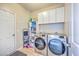 Well-organized laundry room features modern washer and dryer, shelving, and storage cabinets at 134 Comiskey Park Cir, Summerville, SC 29485