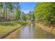 Scenic view of the neighborhood pond, providing a natural and calming backdrop to the surrounding homes and green spaces at 134 Comiskey Park Cir, Summerville, SC 29485