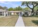 Charming one-story white brick home with a manicured lawn and inviting walkway at 1387 W Lenevar Dr, Charleston, SC 29407