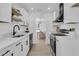 Bright kitchen with white cabinets, floating shelves, stainless appliances, and open concept design at 1387 W Lenevar Dr, Charleston, SC 29407