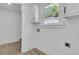 Bright laundry room boasts crisp white walls, a window, and modern fixtures at 1387 W Lenevar Dr, Charleston, SC 29407