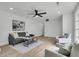 Bright living room with modern ceiling fan, grey couch, accent wall and recessed lighting at 1387 W Lenevar Dr, Charleston, SC 29407