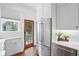 Modern kitchen features stainless steel fridge, gas cooktop and white cabinets and countertops at 139 Tradd St # 2, Charleston, SC 29401