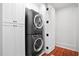 Laundry room featuring stacked washer and dryer with white cabinets and wood floors at 139 Tradd St # 2, Charleston, SC 29401