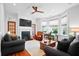 Bright living room with a fireplace, bay window, hardwood floors, comfortable seating, and ceiling fan at 139 Tradd St # 2, Charleston, SC 29401