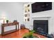 Bright living room with fireplace, hardwood floors, display shelves, and stylish decor at 139 Tradd St # 2, Charleston, SC 29401