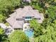 Aerial view of a luxurious home with a backyard pool surrounded by lush trees at 14 Royal Beach Dr, Kiawah Island, SC 29455