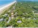 Secluded luxury home surrounded by mature trees near a white sandy beach and waterway at 14 Royal Beach Dr, Kiawah Island, SC 29455