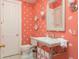 Charming bathroom featuring coral walls, coral patterned wallpaper, and a traditional vanity with a square undermount sink at 14 Royal Beach Dr, Kiawah Island, SC 29455