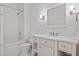 The all-white bathroom features a shower-tub and vanity with marble countertop at 14 Royal Beach Dr, Kiawah Island, SC 29455