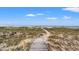 Picturesque wooden path leading to a serene beach with sand dunes and ocean views at 14 Royal Beach Dr, Kiawah Island, SC 29455
