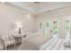 Bright bedroom featuring neutral decor, tray ceiling, and French doors leading to a private balcony at 14 Royal Beach Dr, Kiawah Island, SC 29455