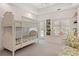 Bright bedroom featuring a white bunk bed, a window seat with shutters, and built-in shelving at 14 Royal Beach Dr, Kiawah Island, SC 29455
