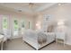 Bright bedroom featuring neutral decor, tray ceiling, and French doors leading to a private balcony at 14 Royal Beach Dr, Kiawah Island, SC 29455