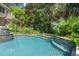 A luxury backyard pool features lush landscaping and a custom waterfall feature at 14 Royal Beach Dr, Kiawah Island, SC 29455