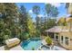 Gorgeous backyard pool and spa surrounded by lush greenery and a screened-in porch at 14 Royal Beach Dr, Kiawah Island, SC 29455