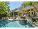 Beautiful backyard pool with waterfall feature and screened-in porch of this luxury home at 14 Royal Beach Dr, Kiawah Island, SC 29455
