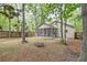 Backyard featuring a fire pit, mature trees, a wooden fence, and an outdoor area at 1453 Joy Ave, Charleston, SC 29407