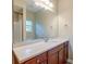 Bathroom vanity featuring a stone countertop and large mirror reflecting a shower and window at 1453 Joy Ave, Charleston, SC 29407