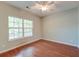 Cozy bedroom featuring hardwood flooring, a ceiling fan and a large window providing a pleasant view at 1453 Joy Ave, Charleston, SC 29407