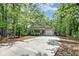 Charming single-story home featuring a well-manicured lawn, mature trees, and a driveway leading to an attached garage at 1453 Joy Ave, Charleston, SC 29407