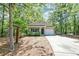 Inviting single-story home with a cozy front porch, lush trees, and a well-maintained lawn with an attached garage at 1453 Joy Ave, Charleston, SC 29407