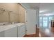 Convenient laundry area located near the living space, equipped with a washer, dryer, and shelving at 1453 Joy Ave, Charleston, SC 29407