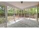 Screened porch featuring a concrete flooring, protection from the elements, and views of the wooded backyard at 1453 Joy Ave, Charleston, SC 29407