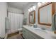 Double vanity bathroom featuring marble countertops, dual decorative mirrors, and tiled flooring at 1535 Capel St, Mount Pleasant, SC 29466