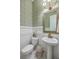 Charming powder room with patterned wallpaper, pedestal sink, and decorative mirror at 1535 Capel St, Mount Pleasant, SC 29466