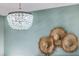 Stylish chandelier illuminates decorative wall hats in this bedroom with aqua walls at 1535 Capel St, Mount Pleasant, SC 29466
