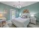 Charming bedroom with a queen-sized bed, aqua walls, decorative hats, and an ornate chandelier at 1535 Capel St, Mount Pleasant, SC 29466