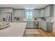 Light-filled kitchen featuring grey cabinets, stainless steel appliances, and a large white marble island at 1535 Capel St, Mount Pleasant, SC 29466