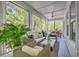 Relaxing screened porch area with wicker furnishings and ceiling fan overlooking a wooded area at 1535 Capel St, Mount Pleasant, SC 29466