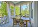 Outdoor dining area on the porch offering wooded views and fresh air for entertaining guests at 1535 Capel St, Mount Pleasant, SC 29466