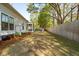 Expansive backyard with a screened porch, storage unit, lush lawn, and a wooden fence at 1543 Gemstone Dr, Mount Pleasant, SC 29464