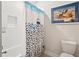 Bathroom with white subway tile, shower curtain with fish, toilet, and decorative artwork at 1543 Gemstone Dr, Mount Pleasant, SC 29464