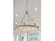 Modern, round chandelier with gold accents and candelabra bulbs hanging from a white, plank ceiling at 1543 Gemstone Dr, Mount Pleasant, SC 29464