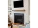 Modern fireplace with a mounted TV, wooden mantle, and built-in shelving for a cozy entertainment space at 1543 Gemstone Dr, Mount Pleasant, SC 29464