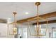 Elegant kitchen lighting featuring rustic wood beams and two gold pendant lights at 1543 Gemstone Dr, Mount Pleasant, SC 29464