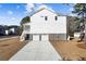 Rear exterior view of a two-story house with a two-car garage and ample parking space at 1577 Periwinkle Dr, Mount Pleasant, SC 29466