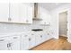 Modern kitchen featuring white cabinets, stainless steel range hood, white backsplash, and wood flooring at 1577 Periwinkle Dr, Mount Pleasant, SC 29466