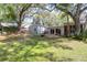 Large backyard features lush green grass, mature trees, an outdoor fireplace, and a patio for entertaining at 17 24Th Ave, Isle of Palms, SC 29451