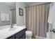Bathroom with a single sink vanity, toilet, and shower/tub combo with a colorful striped shower curtain at 17 24Th Ave, Isle of Palms, SC 29451
