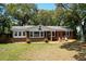Charming brick home with a cozy front porch and lush trees, perfect for a relaxing coastal lifestyle at 17 24Th Ave, Isle of Palms, SC 29451