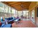Relaxing screened-in patio with comfortable seating, a ceiling fan, and views of the surrounding trees at 17 24Th Ave, Isle of Palms, SC 29451