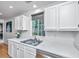 Bright kitchen featuring a stainless steel sink, white cabinets, and quartz countertops at 1722 S Nicole Pl, Charleston, SC 29414