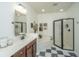 This bathroom has a single vanity with a corner tub, glass door shower, and black and white tiled floors at 2013 Grey Marsh Rd, Mount Pleasant, SC 29466