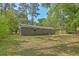 Brick home's backyard with a manicured lawn and mature trees, ideal for outdoor enjoyment at 202 Oak Cir, Walterboro, SC 29488